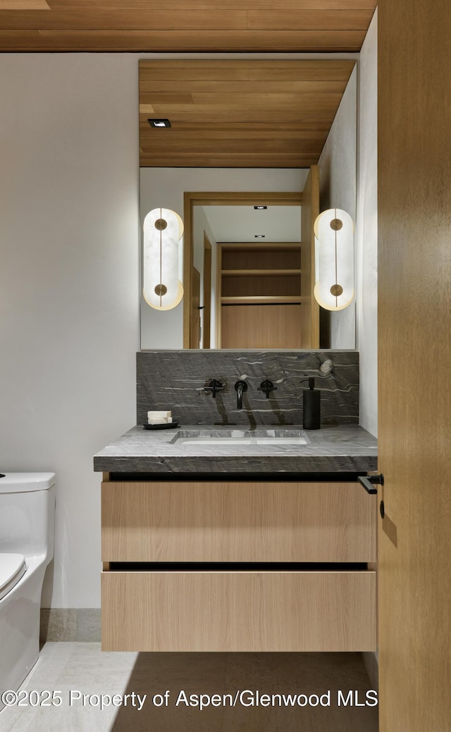 half bath featuring wood ceiling, backsplash, vanity, and toilet