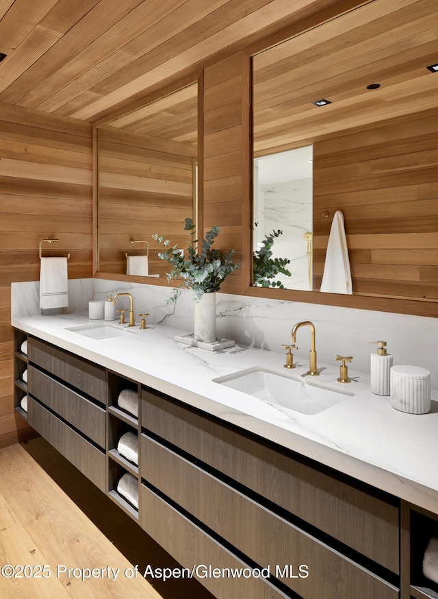 full bathroom with wooden ceiling, a sink, wooden walls, and double vanity