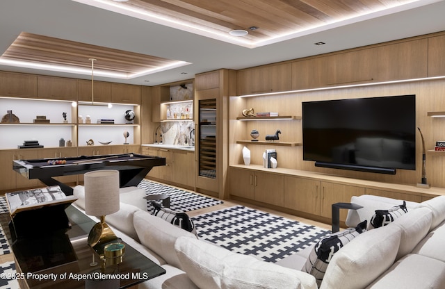 playroom featuring a tray ceiling and wood ceiling