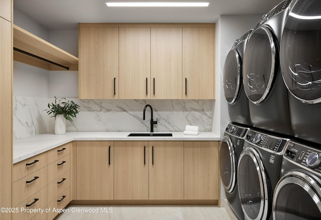 washroom with stacked washer and dryer, a sink, and cabinet space