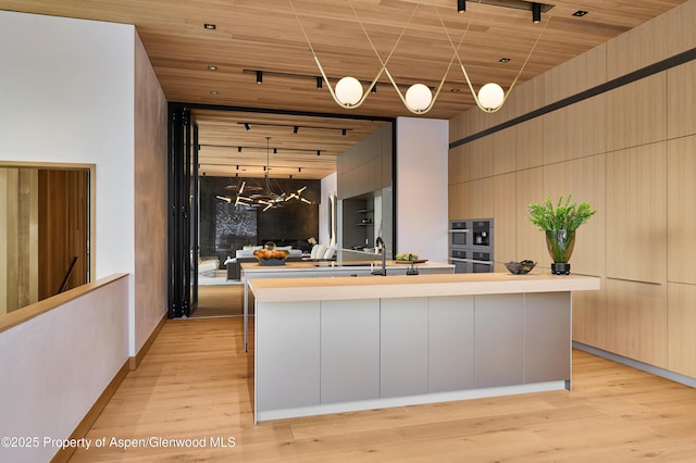 kitchen with light wood-style floors, modern cabinets, and light countertops