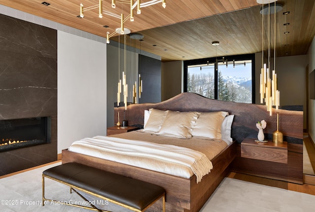 bedroom featuring wooden ceiling and a fireplace