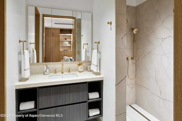 bathroom with a marble finish shower and vanity