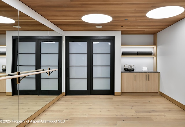 interior space with wooden ceiling, baseboards, and light wood-style floors