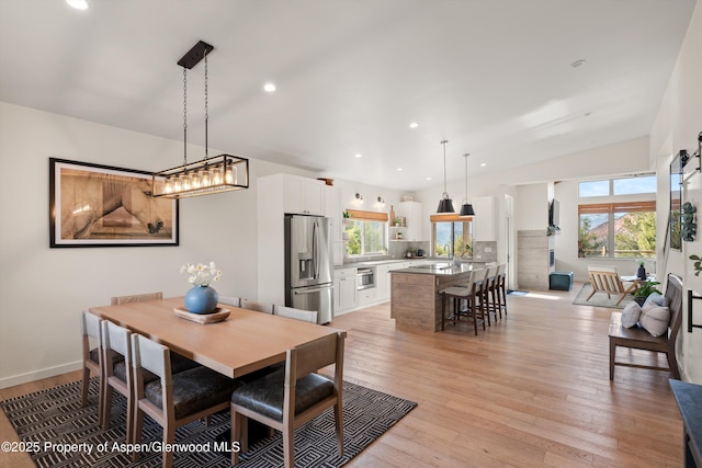 dining space featuring recessed lighting, light wood-style floors, baseboards, and a wealth of natural light