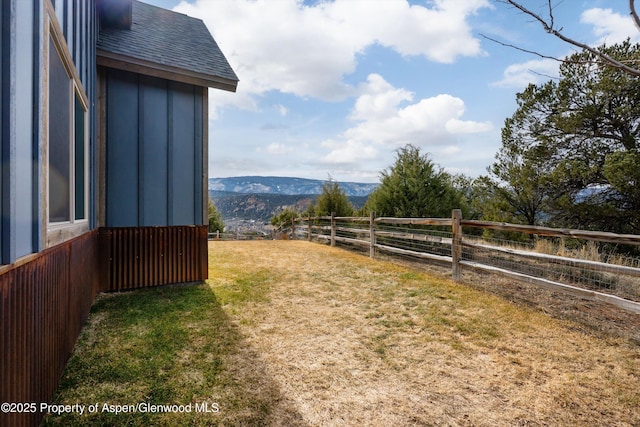 view of yard featuring fence and a mountain view