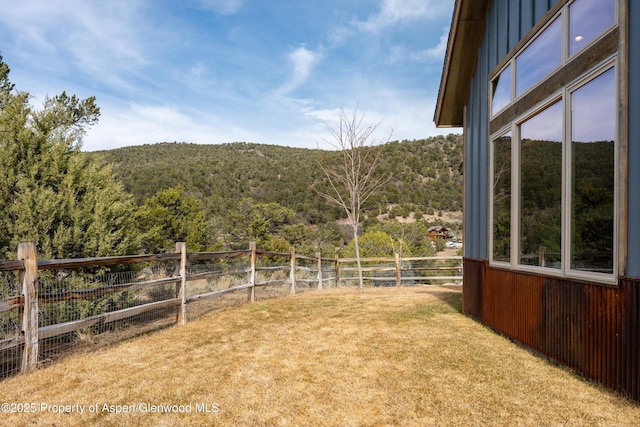 view of yard with a view of trees and fence