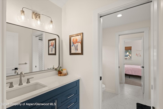 bathroom featuring recessed lighting, toilet, vanity, and baseboards