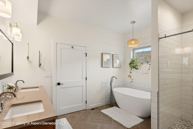 bathroom with a sink, tiled shower, a soaking tub, and tile patterned flooring