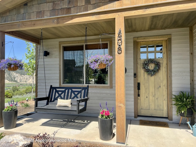 view of exterior entry featuring covered porch