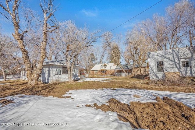 snowy yard with an outbuilding