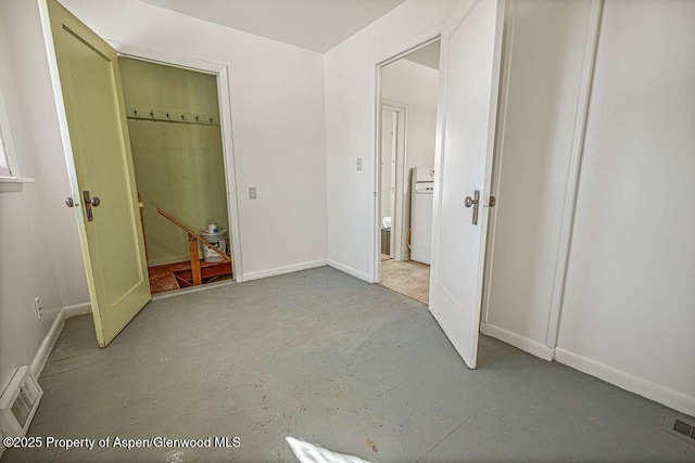 unfurnished bedroom with ensuite bathroom, concrete floors, visible vents, and baseboards