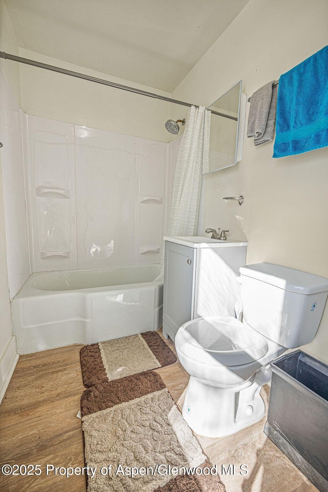 bathroom featuring vanity, shower / tub combo, wood finished floors, and toilet