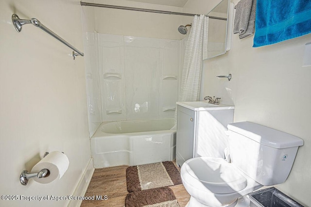 full bathroom featuring toilet, vanity, wood finished floors, and shower / bath combo with shower curtain