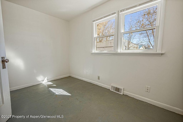 empty room featuring baseboards and visible vents