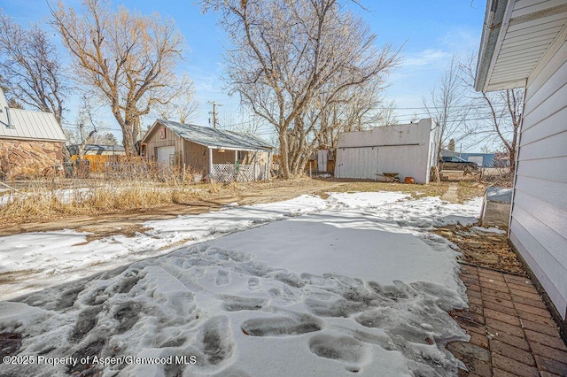 yard layered in snow featuring an outbuilding and a jacuzzi