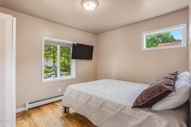 1114 Blake Ave, Glenwood Springs, CO 81601 - bedroom with baseboard heating, multiple windows, and wood finished floors
