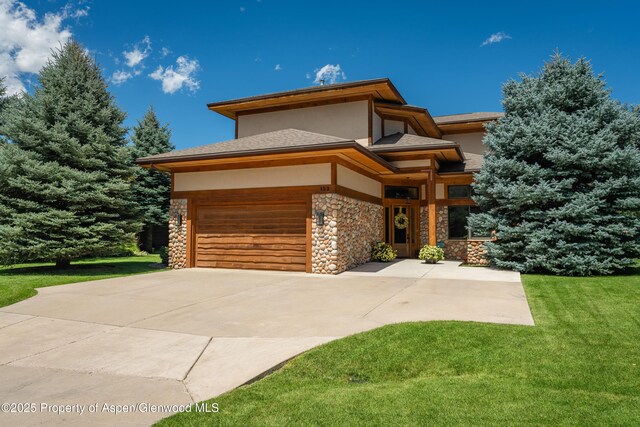 123 Corral Dr, Carbondale, CO 81623 - prairie-style home featuring concrete driveway, stone siding, an attached garage, a front yard, and stucco siding