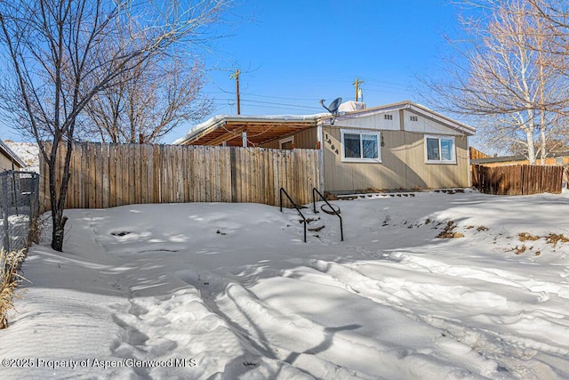 view of snow covered back of property