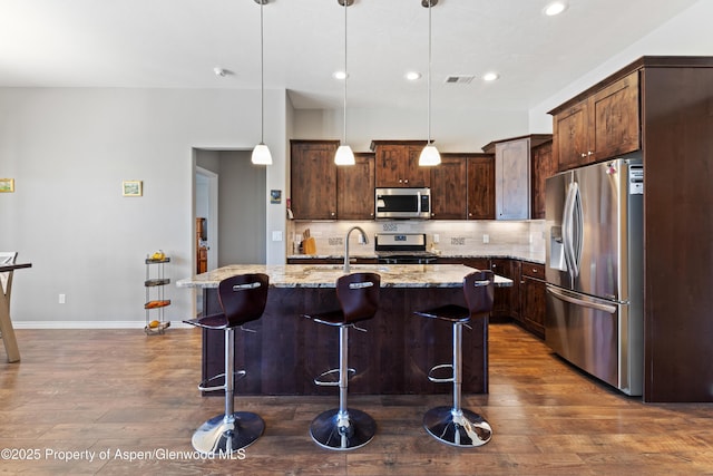 1326 Fairway Dr, Fruita, CO 81521 - kitchen featuring visible vents, dark wood-style floors, stainless steel appliances, dark brown cabinets, and backsplash