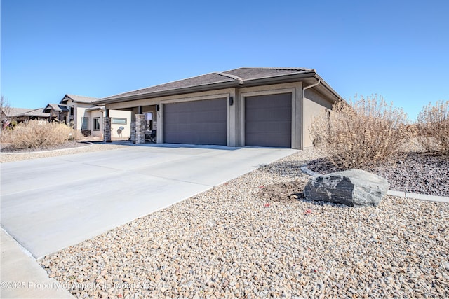 exterior space with a garage, concrete driveway, and stucco siding