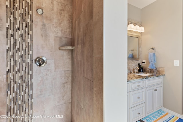 1326 Fairway Dr, Fruita, CO 81521 - bathroom featuring tiled shower, vanity, and baseboards