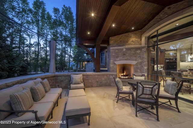 patio terrace at dusk with an outdoor living space with a fireplace