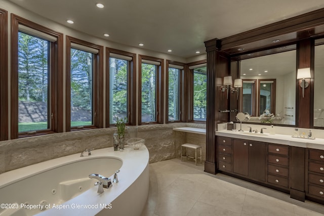 bathroom with tile patterned floors, vanity, and tiled tub