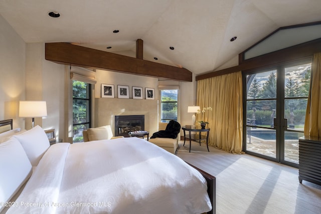 carpeted bedroom featuring access to outside, vaulted ceiling, and multiple windows