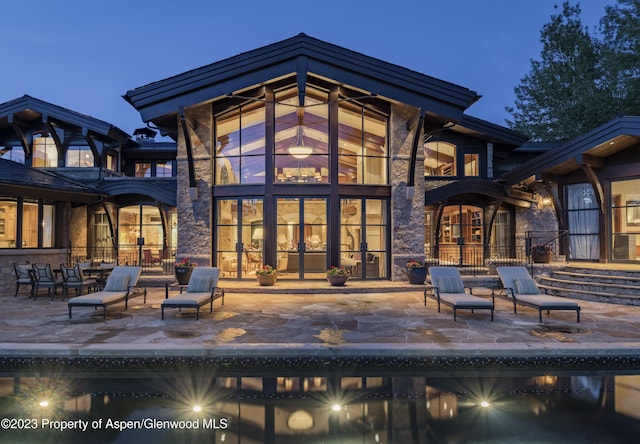 back house at dusk with a patio area