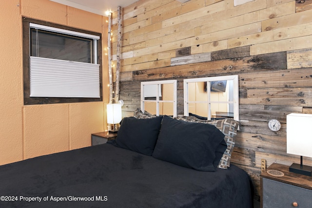 bedroom featuring wooden walls