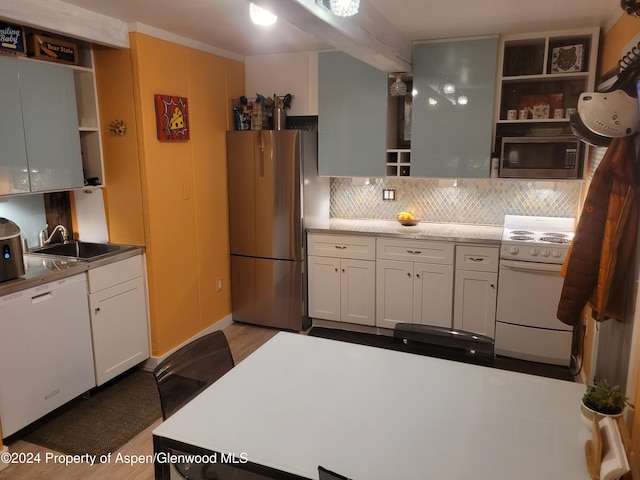 kitchen featuring white cabinets, sink, light wood-type flooring, tasteful backsplash, and stainless steel appliances