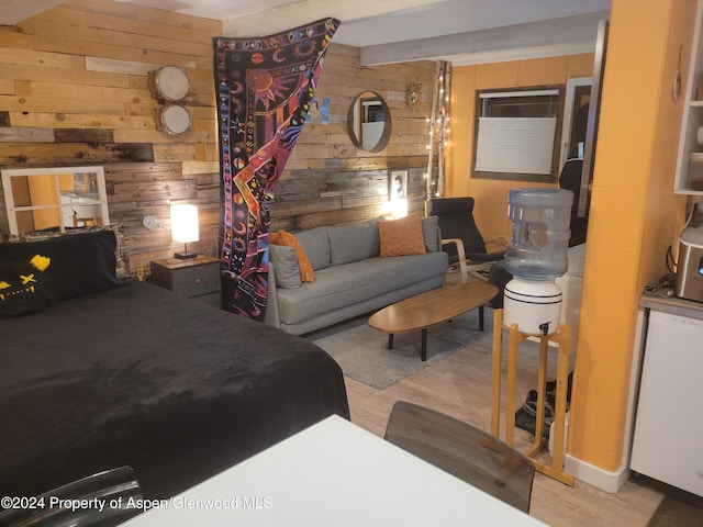 bedroom with wooden walls and light hardwood / wood-style flooring