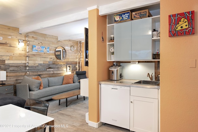 interior space featuring beam ceiling, white cabinetry, dishwasher, wooden walls, and light wood-type flooring