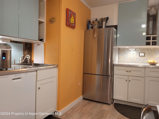 kitchen with stainless steel refrigerator, white cabinetry, dishwasher, light hardwood / wood-style floors, and decorative backsplash