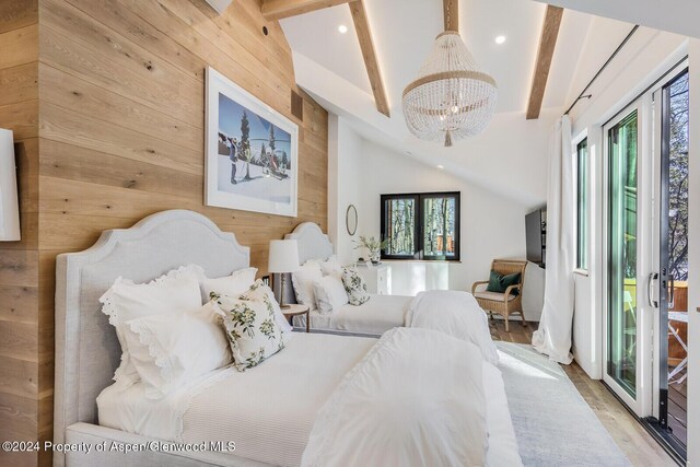 bedroom with access to exterior, wooden walls, lofted ceiling with beams, and a notable chandelier