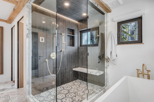 bathroom with beamed ceiling, a tile shower, and a wealth of natural light