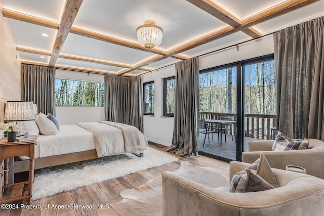 bedroom featuring light hardwood / wood-style floors, a notable chandelier, and coffered ceiling