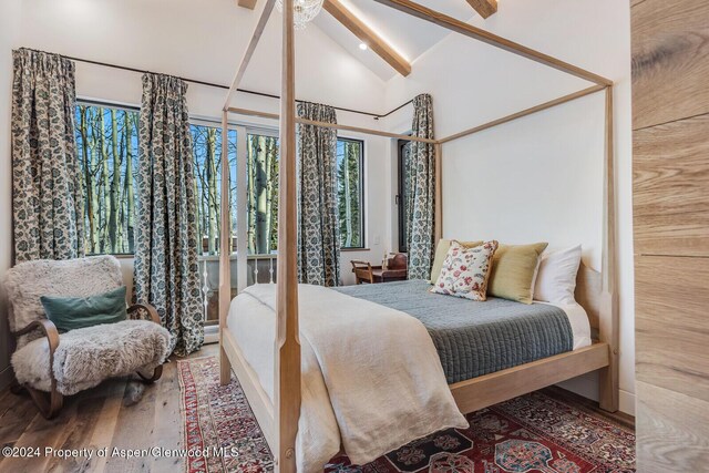 bedroom featuring vaulted ceiling with beams, ceiling fan, and hardwood / wood-style floors