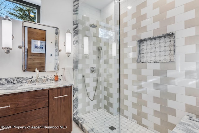 bathroom featuring tiled shower and vanity