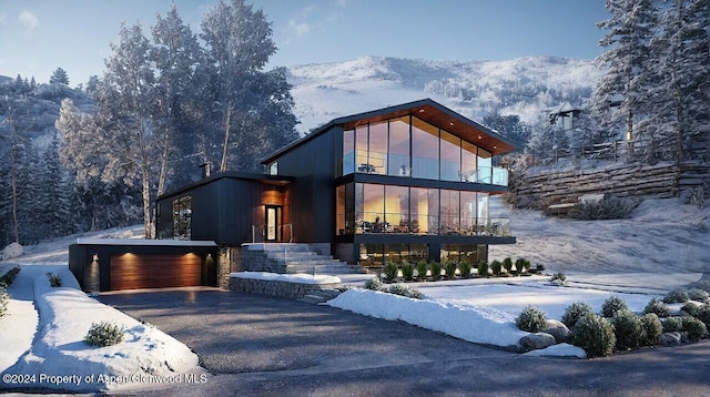 view of front of house with an attached garage, driveway, and a mountain view
