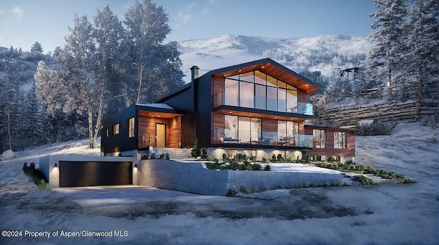 view of front of home with a garage, driveway, and a mountain view