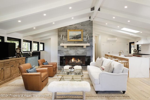 living area with recessed lighting, light wood-style floors, a tiled fireplace, and vaulted ceiling with beams