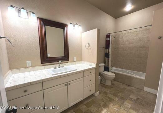 full bathroom featuring vanity, shower / tub combo, and toilet