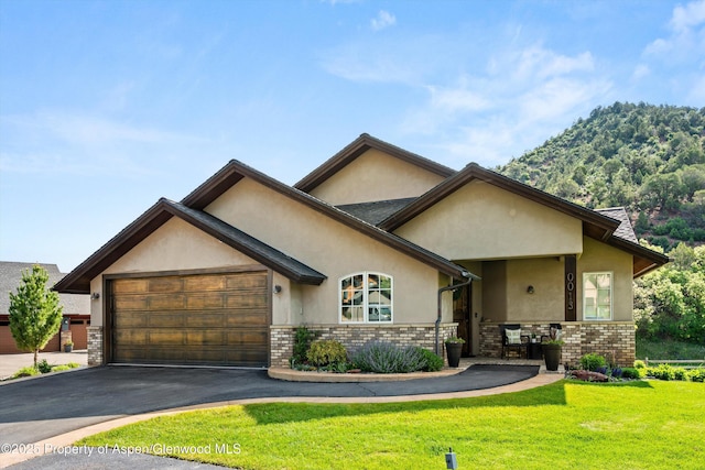 13 Laird Ln, Glenwood Springs, CO 81601 - view of front of home with stucco siding, brick siding, a garage, and driveway