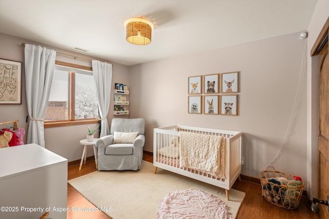 13 Laird Ln, Glenwood Springs, CO 81601 - bedroom with wood finished floors, baseboards, and a crib