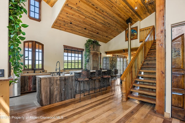 200 Forest Dr, Carbondale, CO 81623 - kitchen with high vaulted ceiling, light wood finished floors, wooden ceiling, a breakfast bar area, and dark brown cabinetry