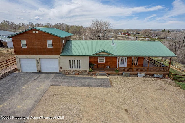 1020 Thompson Way, Craig, CO 81625 - view of front of home with fence, covered porch, metal roof, an attached garage, and driveway