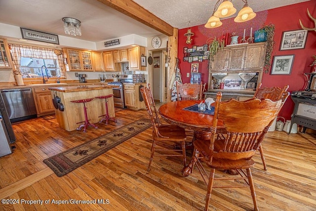 1020 Thompson Way, Craig, CO 81625 - dining space featuring light wood-style floors, a textured ceiling, and beam ceiling