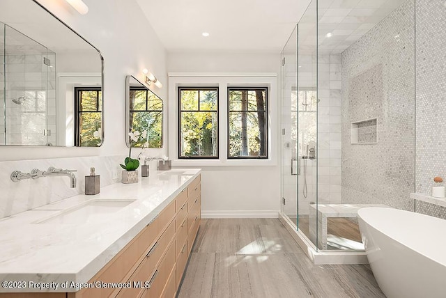 bathroom with shower with separate bathtub, vanity, and wood-type flooring